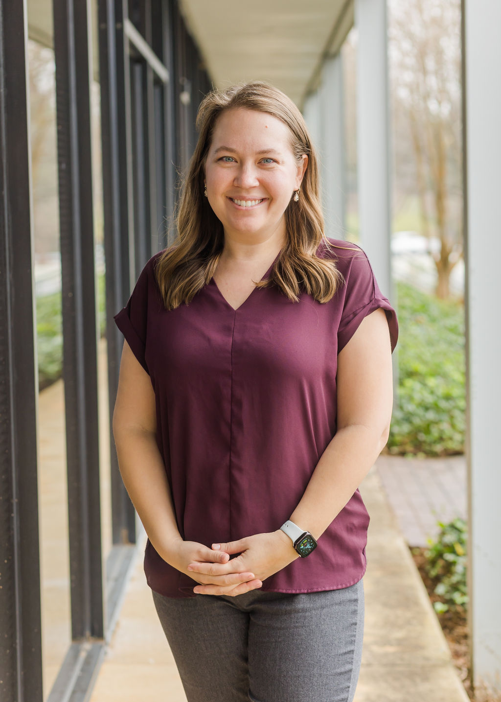 Lady standing and smiling in a purple shirt